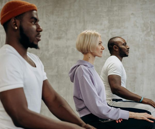 Diverse group of people sitting peacefully in a meditation circle.